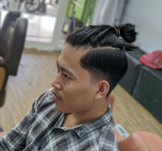 A photograph depicting an Asian male with a Samurai bun and an undershave  hairstyle - Man Bun Hairstyle